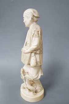 A Japanese carved ivory figure of a farmer, Meiji period, c.1900, signed, carrying a lantern on a stick, maize grows at his feet, a toad climbs on one arm, height 20.5cm